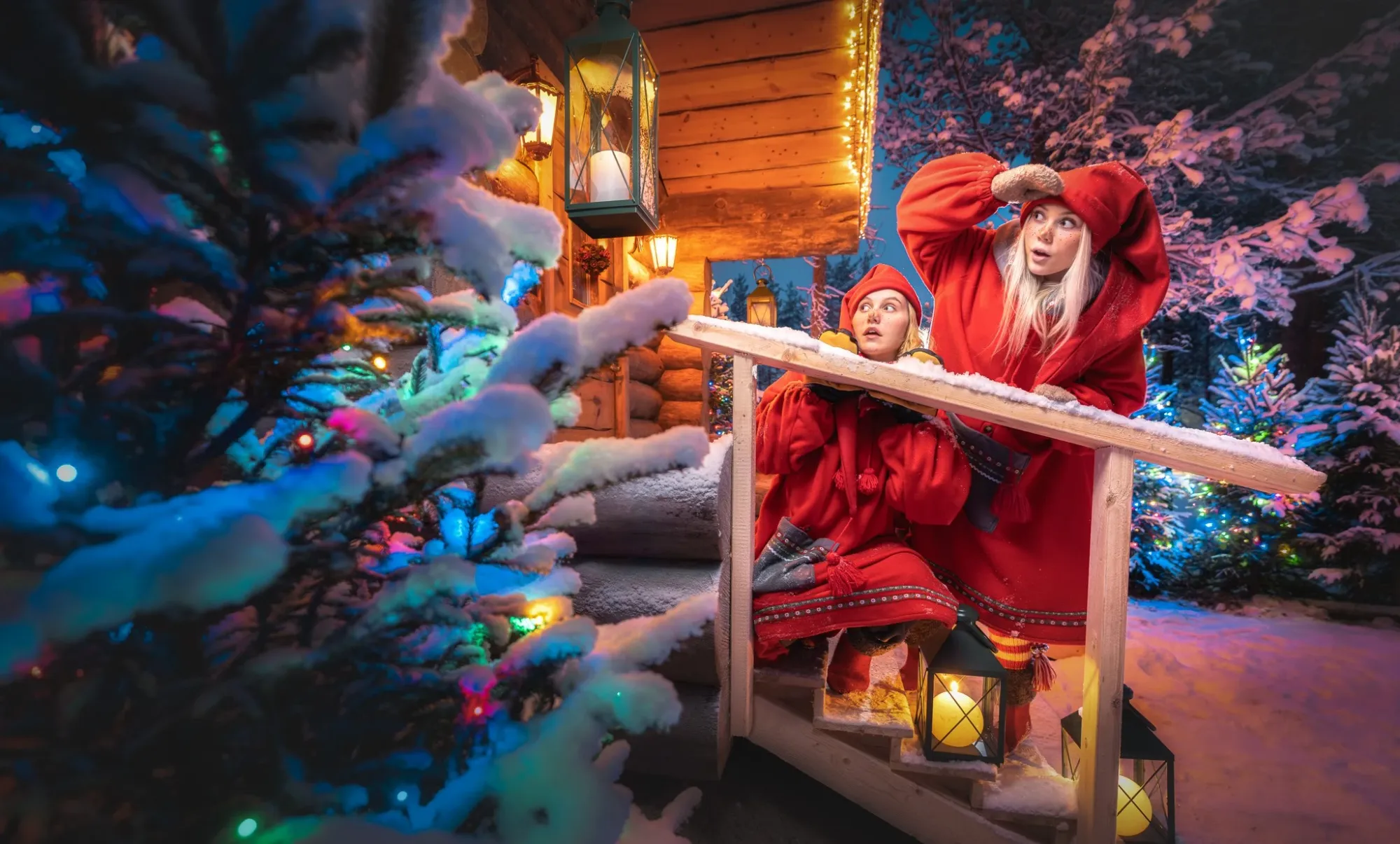 elfos afuera de una cabaña en la villa de santa claus en el círculo polar ártico.