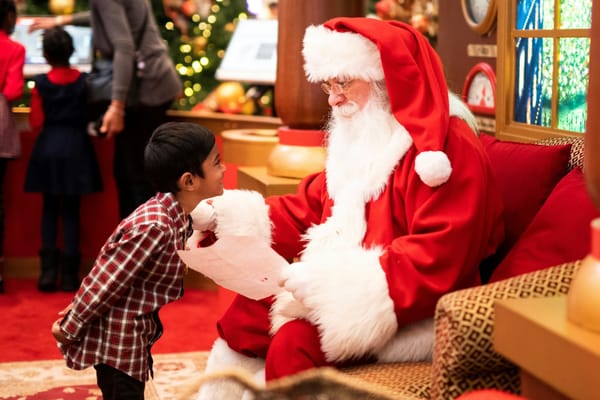 Un niño pequeño de frente a Santa Claus en la Villa de Santa Claus en el Círculo Polar Ártico.